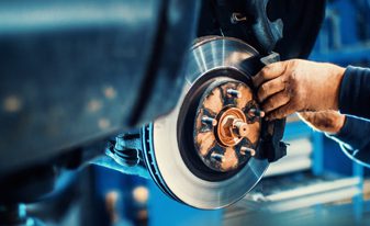 Mullinax Body Shop | service technician working on rotors in shop